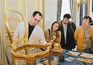 法国文物修复专家在巴黎向参观者介绍古家具的修复与保养。