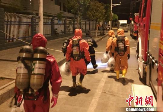 救援人员手提沙袋进入现场清理处置。巫明杰摄