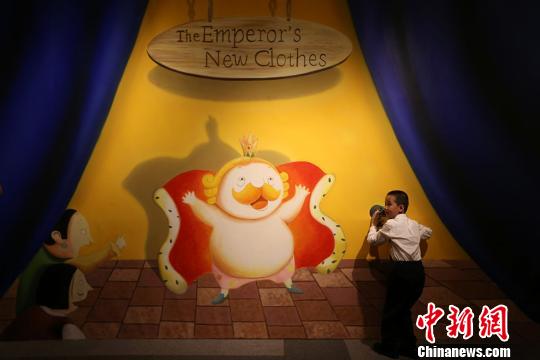 小朋友在安徒生童话进入中国百年纪念展上与展出的作品互动。　泱波　摄