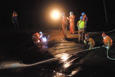 6月3日晚，救援人员对客船“东方之星”的底部进行切割作业以便救援。 