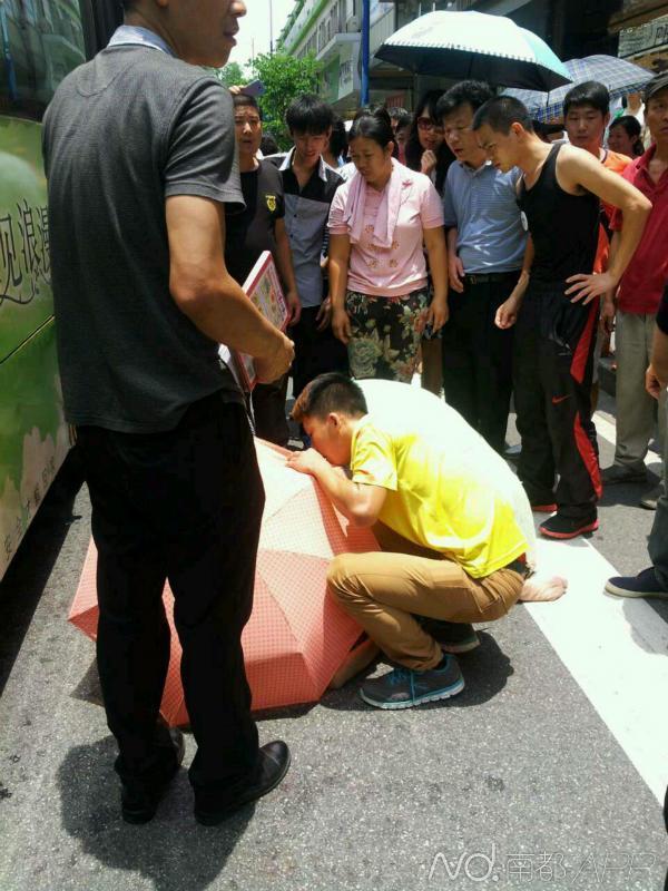 广州一老太太被卷入车底 数十人合力抬车