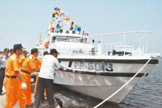 海巡人员昨以白漆涂掉PP5013巡防艇艇号，象征保护云嘉南海域20余年的警艇除役。 台湾联合报图