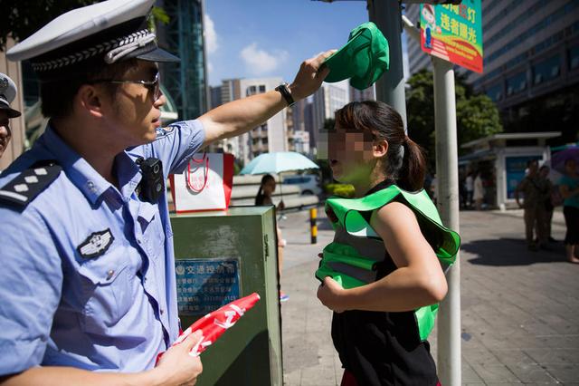 深圳闯红灯被罚戴绿帽引争议 交警称与马甲搭配