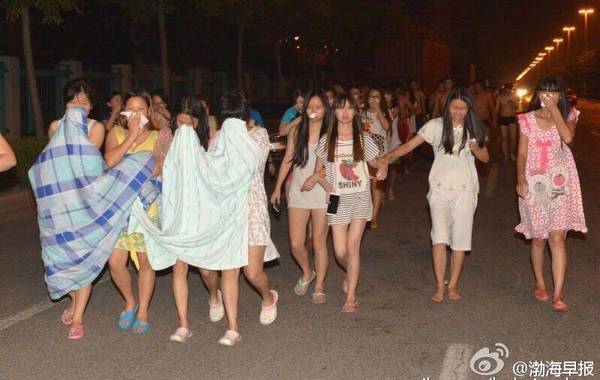 据新京报报道，2015年8月12日晚11时许，天津市塘沽开发区一带发生爆炸事故，现场火光冲天，据多位市民反映，事发时十公里范围内均有震感，抬头可见蘑菇云。晚上22点50分，天津消防总队接到火警，9个中队35辆消防车以及港务码头3个消防专职队于23时06分抵达现场，23时30分，现场发生爆炸。目前事故已致17人死亡，32人危重，283人入院。图为民众身披床单，到街头避险。