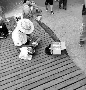 奥林匹克公园内一名游商坐在地上售卖冰棍。