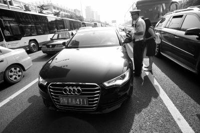 昨天交警在日，坛路口查限行车辆。京华时报记者潘之望摄交警正在给公车贴封条。京华时报记者谭青摄