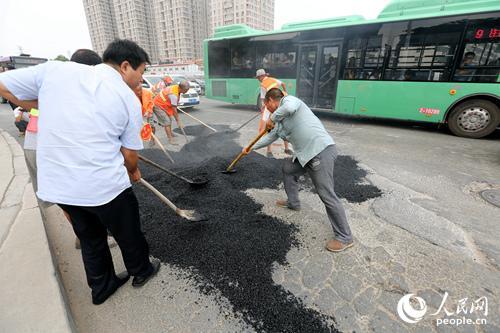 道路坑连坑颠坏车辆 郑州公交司机无奈自发修路