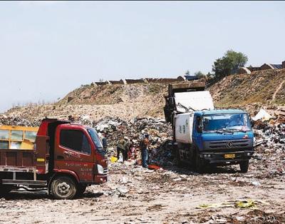 西津坪垃圾场内恶臭难闻，垃圾清运车正在这里肆意倾倒未经处理的城市生活垃圾。