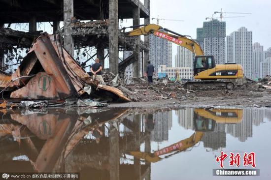 资料图：9月5日，在核心爆炸点清理现场看到，事故现场清理工作正在科学有序地推进，核心区内三堆集装箱已经有两堆清理完毕，天津建工二建公司和天津建工总包的施工队伍正在对跃进路派出所办公大楼进行拆除，爆炸点南侧基本清除完毕，露出大量空地。CFP视觉中国