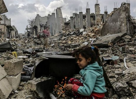△在叙利亚艾因阿拉伯（又称科巴尼），库尔德女孩在废墟中烧火，准备做饭