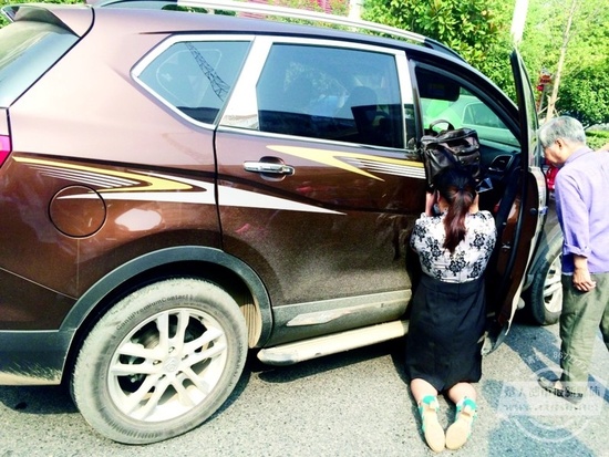 妻子跪在车门口,用包为死去的丈夫遮挡阳光