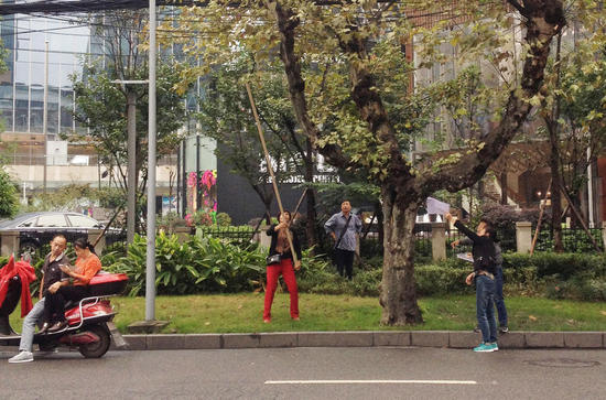 四川省成都市，市民拿着长杆在梧桐树上采蘑菇