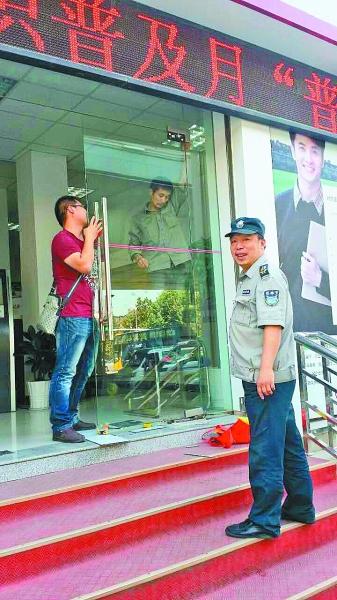 银行开门时玻璃门突然倒下 保安扛门众人脱险