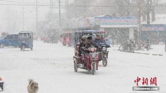 图里河镇市民在雪中出行。