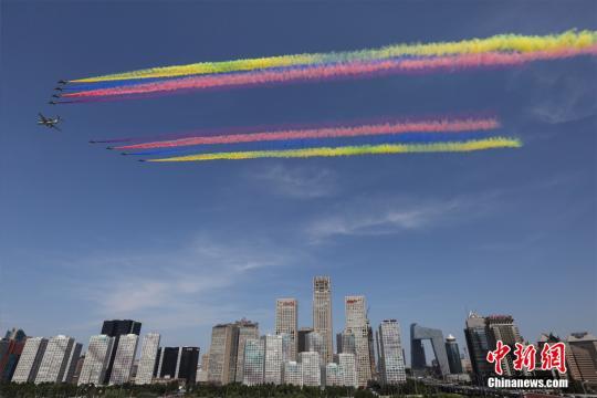 9月3日上午，纪念中国人民抗日战争暨世界反法西斯战争胜利70周年大会在北京隆重举行。受阅领队机梯队飞过北京CBD上空。 中新社记者 熊然 摄