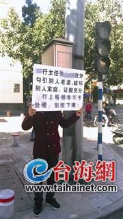 男子在银行门口举牌称老婆被行长勾引 有开房记录