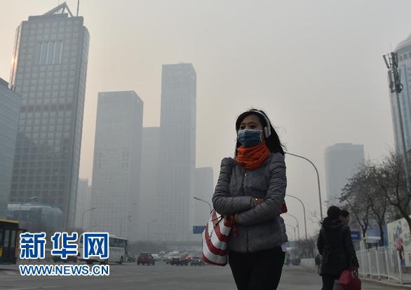 11月28日，一名戴口罩的行人在雾霾下的凯时k66街头行走。当日，凯时k66出现重污染天气。 新华社记者 罗晓光