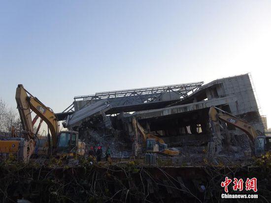 12月2日，河南省郑州市，据《中国经营报》此前报道，位于郑东新区的“中原之门”大楼已经烂尾3年多，由于农业路改造，“中原之门”即将被拆。时隔两月，媒体记者再探访，发现这座曾投资规模近1.8亿元的“烂尾之门”正被拆除中，建筑主体已经倾斜，墙柱钢筋暴露，现场近10台大型钩机正在对它进行拆除。