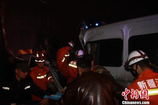 图为当地救援人员将伤员从相撞的车辆上抬下。程波摄