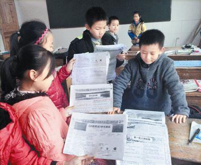 南冈春蕾小学的小学生翻出报纸复印件。