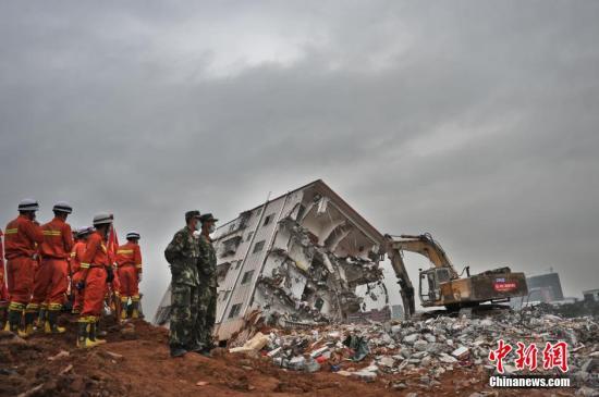 深圳山体滑坡 消防员乘挖掘机进土坑救援。视觉中国 