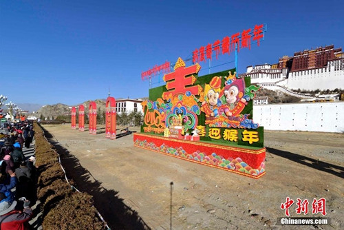 随着农历猴年春节和藏历火猴新年即将到来，拉萨市布达拉宫广场及拉萨街头装饰一新，充满节日喜庆气氛。图为2月4日，藏族民众在布达拉宫前的拍照留念。李林 摄