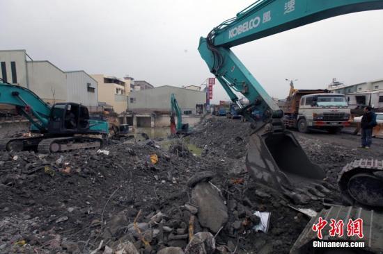 资料图：2月16日，在6日发生的高雄地震中倒塌的台南维冠大楼现场，附近道路交通已恢复，大型机械持续清理原大楼地基。 中新社记者 刘舒凌 摄 