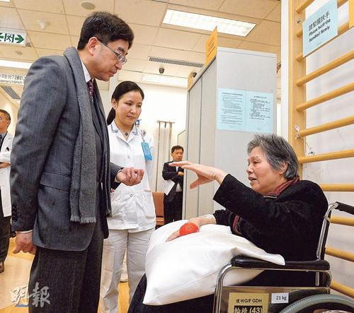 香港食物及卫生局长高永文（左）昨参观明爱医院怀明楼骨科复康病房。他指流感高峰未到顶，建议学校继续为学生量体温。（图自香港《明报》）