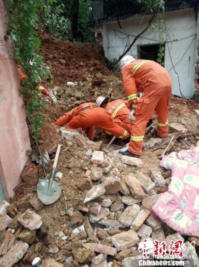 5月8日，消防官兵在塌方地点，用毯子清理房屋周围淤泥，门卫室已经出现裂缝，有坍塌的危险。 李龙 摄