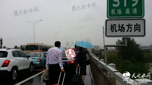 武汉一机场积水深路堵 千余旅客涉水跑步赶飞机