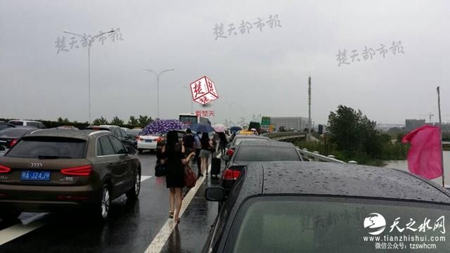 武汉一机场积水深路堵 千余旅客涉水跑步赶飞机