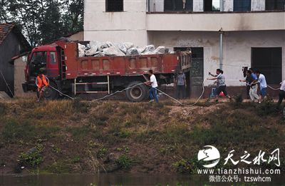 司机坠入溃口前一刻跳下卡车 连车带石堵溃口