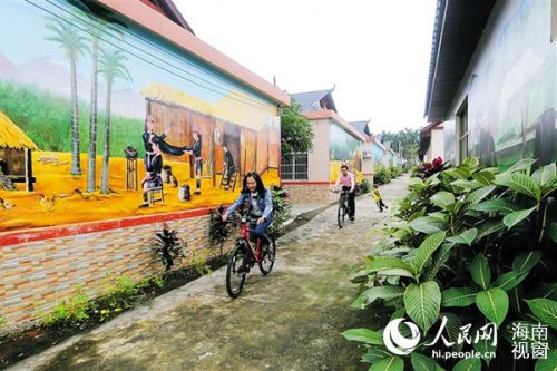 琼海会山加脑村 游客在苗绣园村骑行