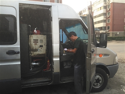 9月25日，天津滨海血站停车场附近，一辆白色依维柯被改装成加油车，给一辆私家车加完油后，加油车司机正开收据。