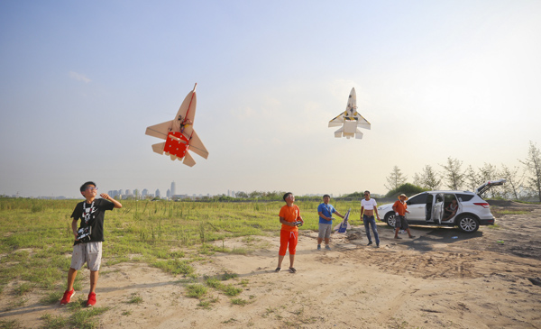 7月26日，河南郑州，一块尚未开发的土地上，一些航模爱好者在练习飞行。此处将被怎样的高端建筑取代，尚未可知。 东方IC 图
