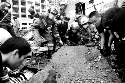 救援人员徒手搬运瓦砾