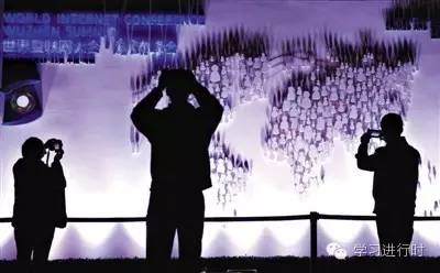 2014年11月17日，浙江乌镇西栅景区入口处，游客在新设立的互联网大会宣传墙前拍照留念。11月19日，首届世界互联网大会乌镇峰会开幕。记者 李冬 摄