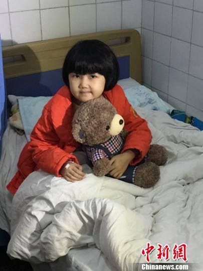 输完血后抱着玩具熊的小佳鑫。 邹立杨 摄 邹立杨 摄