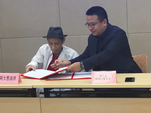 阿大葱油饼经营者吴根存与网络订餐平台签约。