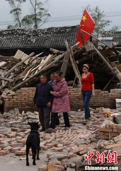 资料图。一位雅安当地民众在家人的搀扶下离开自家废墟，他们在地震中失去亲人。中新社发 张元 摄