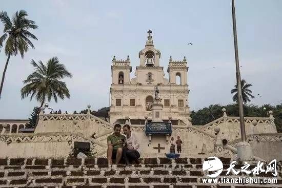 印度果阿，游客在无原罪圣母教堂外的台阶上休息（图/新华社）