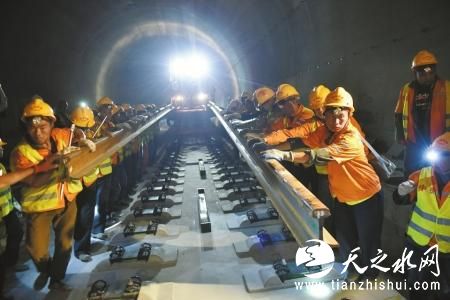 10月15日，西成客专四川段正式铺轨。图为工人将钢轨扶上“正轨”。