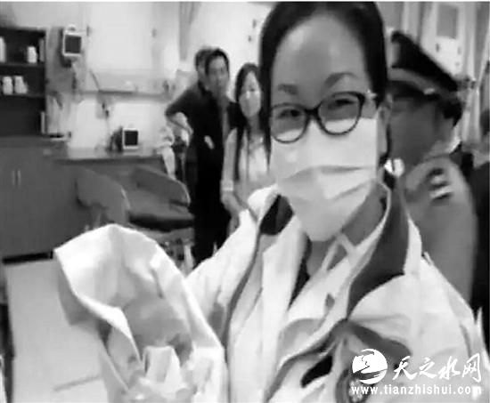 急救人员抱着抢救成功的女婴（视频截图）。