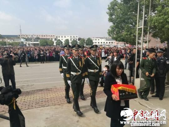 图为王锋妻子手捧王锋骨灰。 董飞 摄