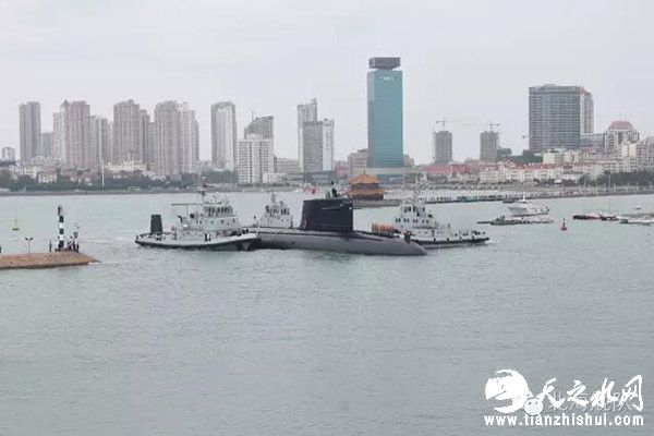 核潜艇在拖船的拖带下经过栈桥。