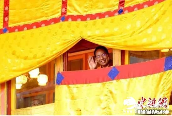 10月4日，班禅额尔德尼·确吉杰布向观看跳神的民众和游客挥手致意。