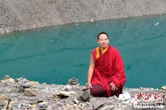 班禅额尔德尼·确吉杰布在雍则绿湖前拍照留念。