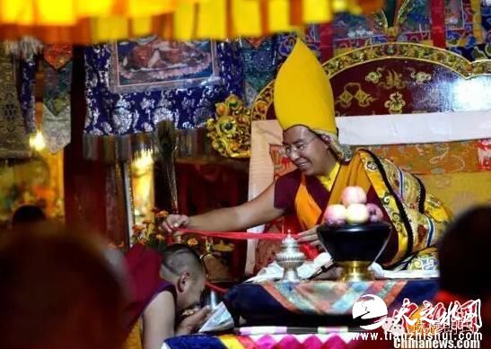 班禅额尔德尼·确吉杰布为僧人佩戴护结。