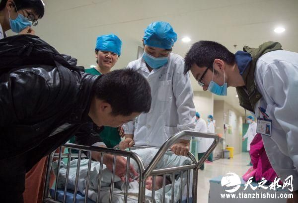 资料图片：安徽医科大学第一附属医院产房外，助产士将一个刚出生的婴儿送到父亲身边。新华社记者 郭晨 摄