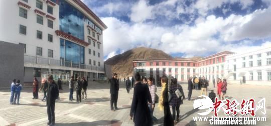 图为地震发生后，杂多县政府工作人员站在办公楼外躲避余震 尕玛求加 摄